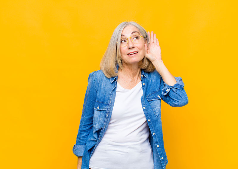 Femme essayant d'entendre ce qu'il se dit 